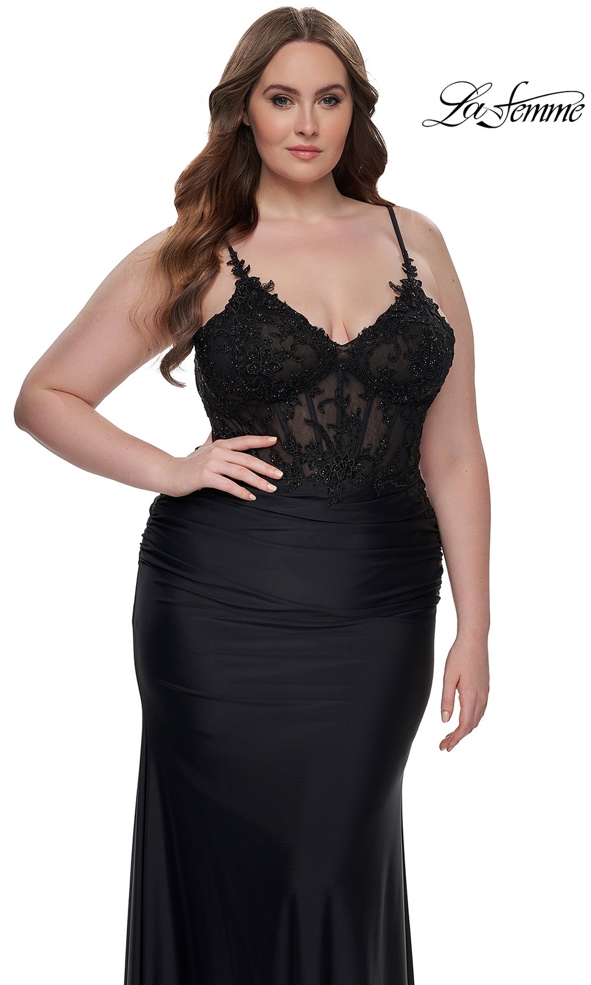 A woman models the La Femme Plus-Size Long Black Prom Dress 32226, featuring a sheer embroidered-lace bodice and thin straps, against a white background.